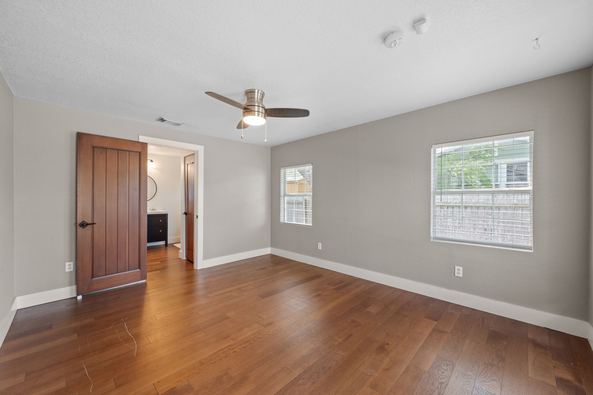 1137 Nickols Avenue Austin, TX 78721 - Photo 13 of 33 Large primary bedroom with wood floors and lots of windows.