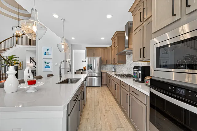 a kitchen with stainless steel appliances a sink a stove top oven a counter space and cabinets