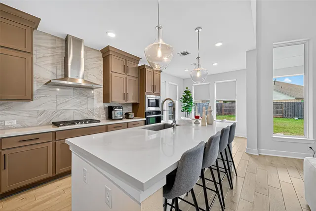 a kitchen with a dining table chairs stainless steel appliances and cabinets