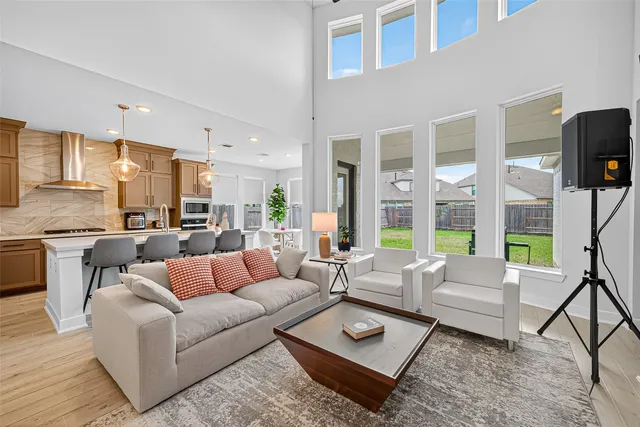 a living room with furniture wooden floor and a large window