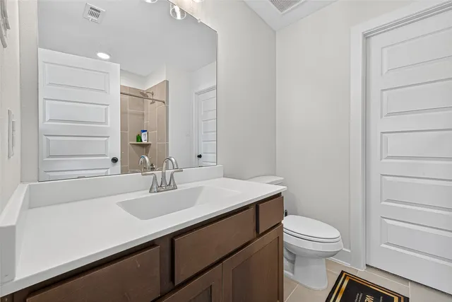 a bathroom with a sink a toilet a vanity and mirror