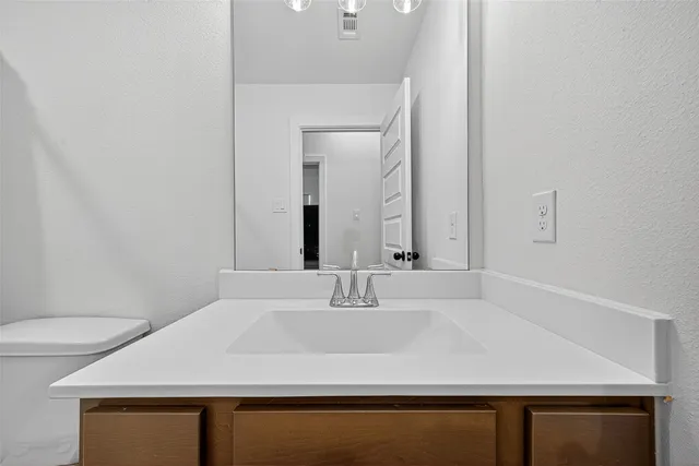 a bathroom with a sink a toilet and mirror