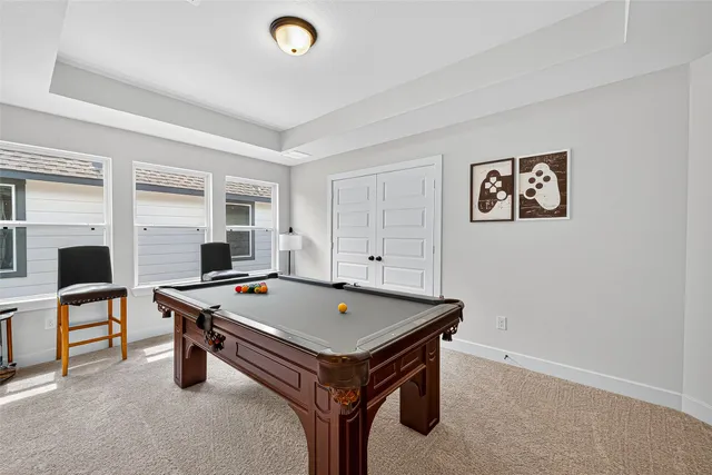 a room with pool table and windows