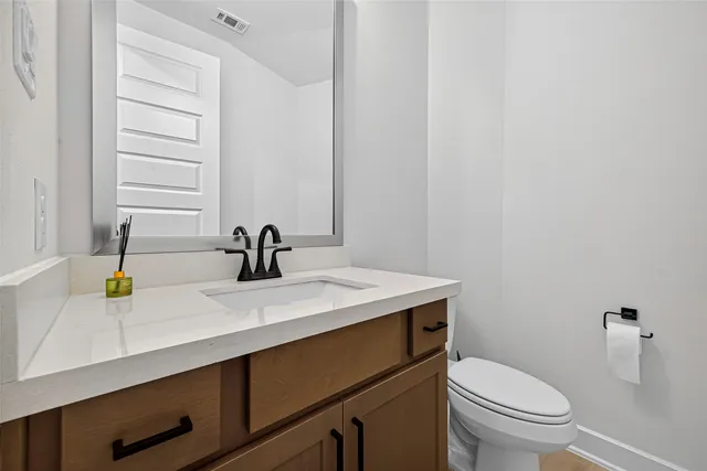 a bathroom with a sink a toilet and a mirror