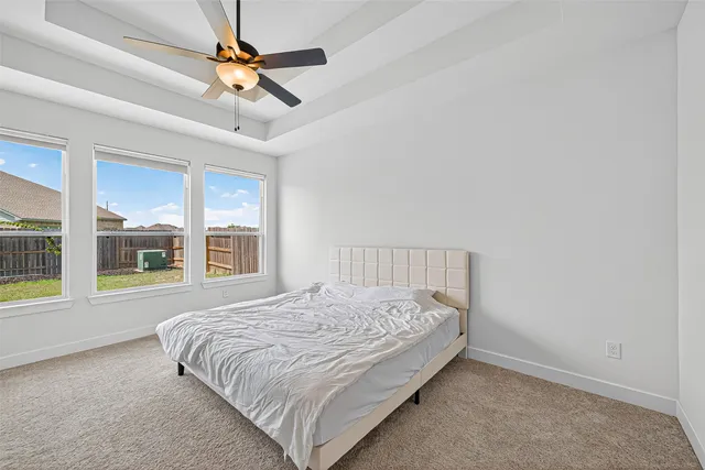 a bedroom with a bed a ceiling fan and window