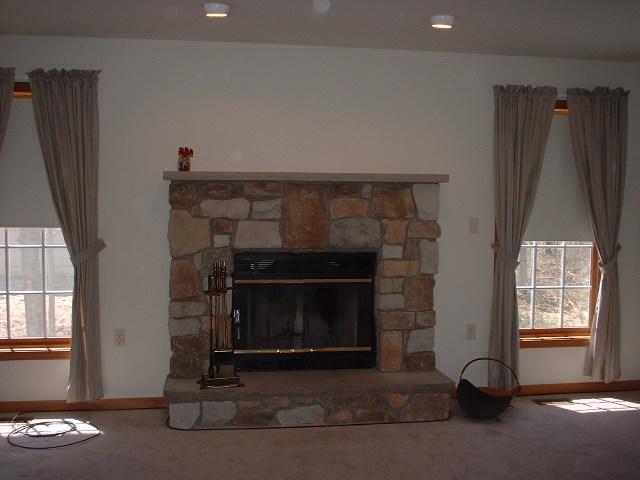 5553 Granite Road Long Pond, PA 18334 - Photo 3 of 8 a living room with a fireplace furniture a rug and a window