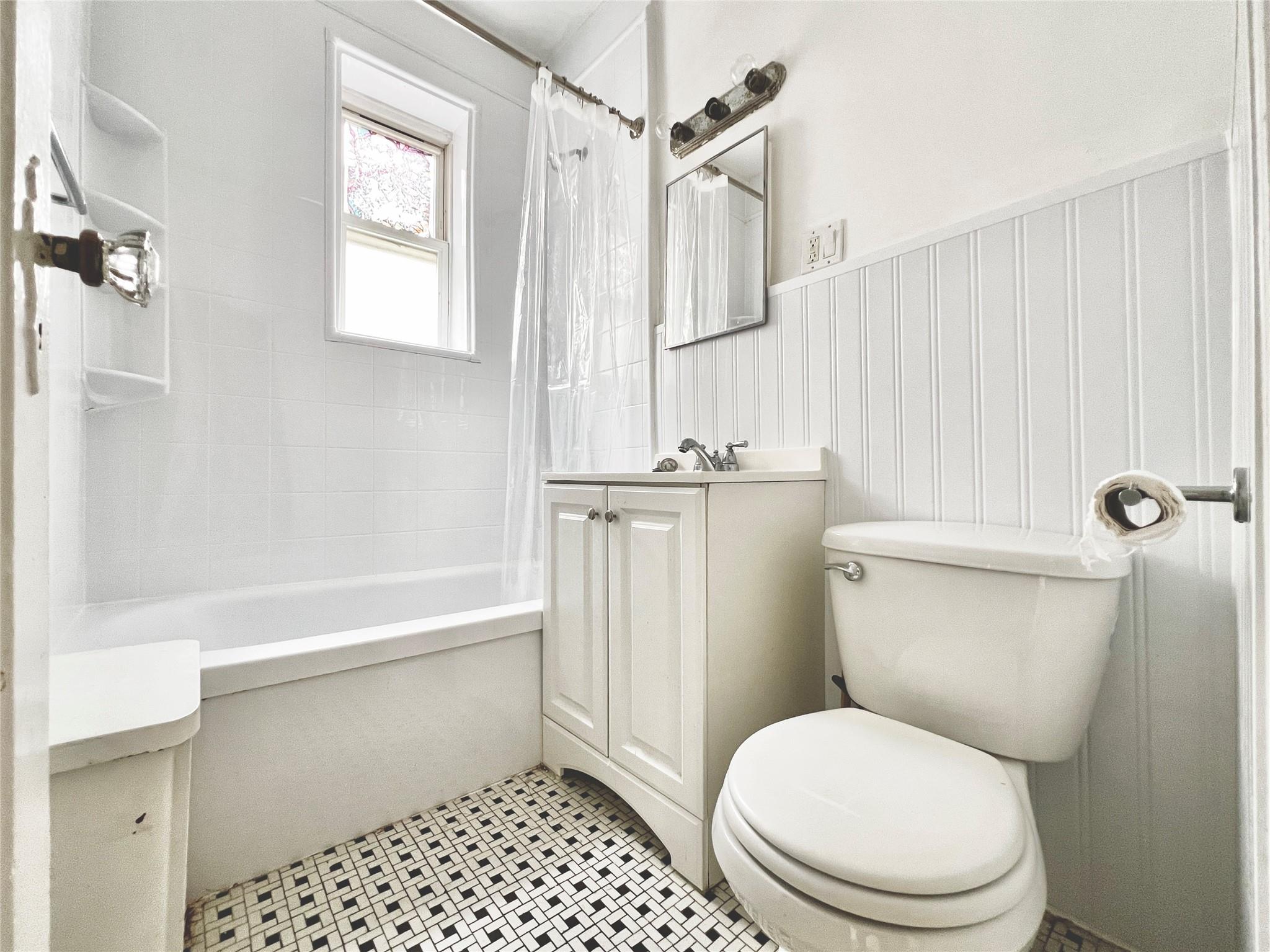 6700 49th Avenue Queens, NY 11377 - Photo 11 of 11 a white toilet sitting next to a bathroom sink and tub