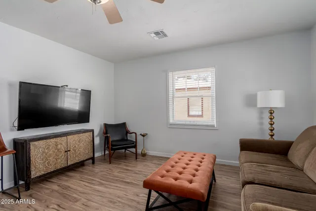 a kitchen with stainless steel appliances granite countertop a stove top oven a sink dishwasher and white cabinets with wooden floor