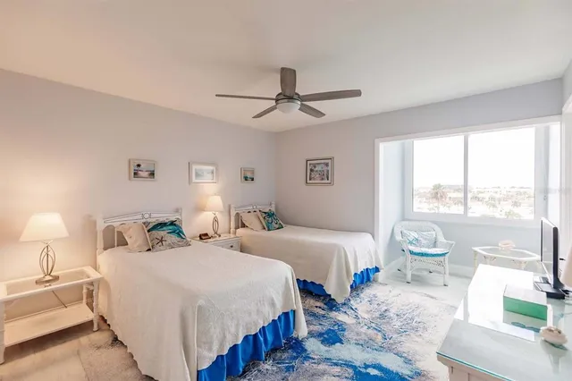 a bedroom with two beds and a large window