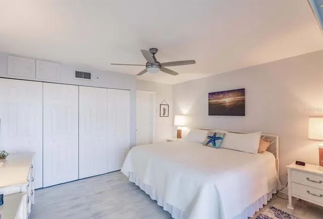 a bedroom with a bed and a ceiling fan
