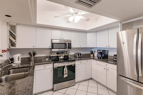 a kitchen with white cabinets sink and stainless steel appliances