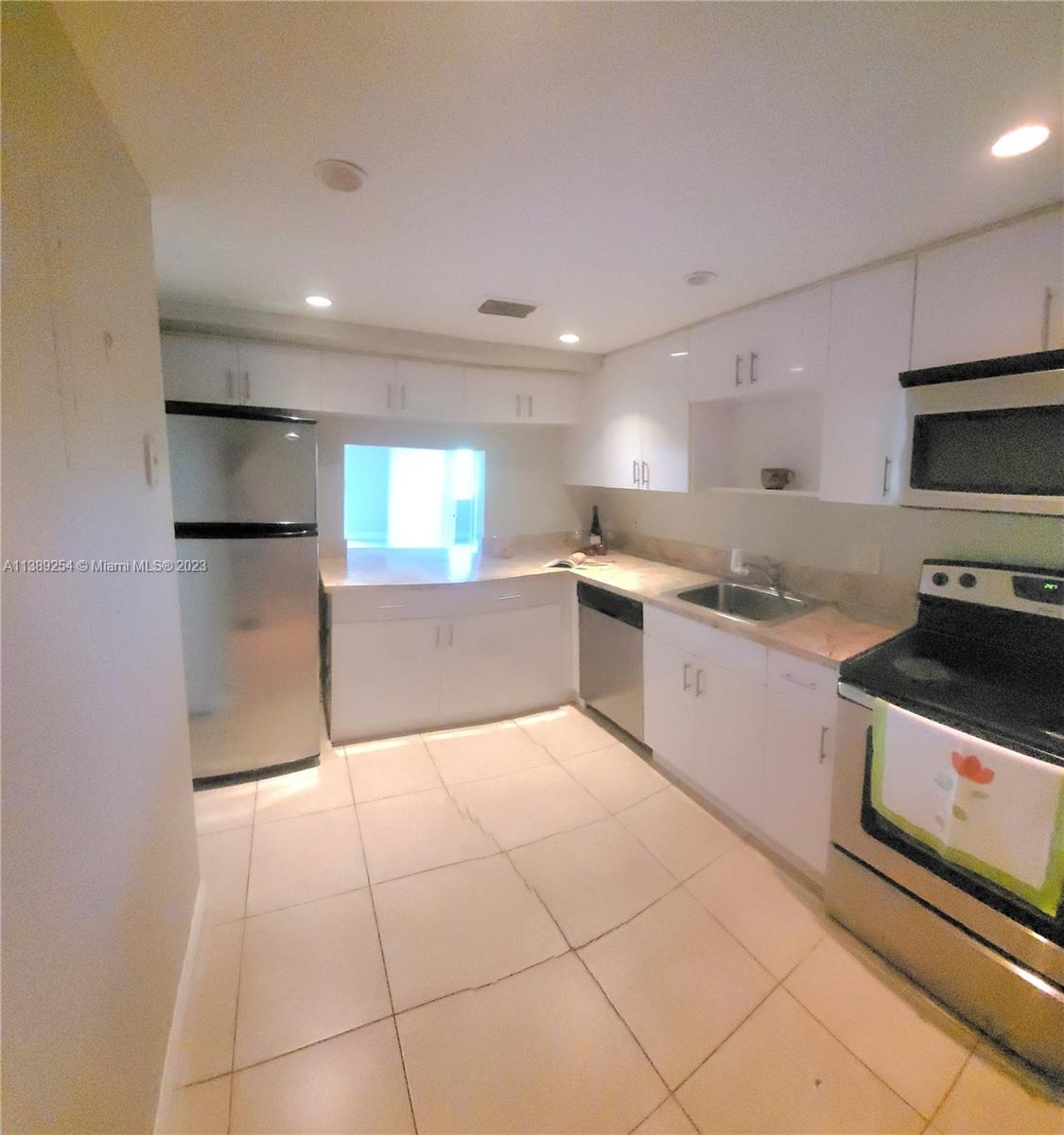 3490 Foxcroft Road, Unit B202 Miramar, FL 33025 - Photo 13 of 29 a large kitchen with a stove a sink and a refrigerator