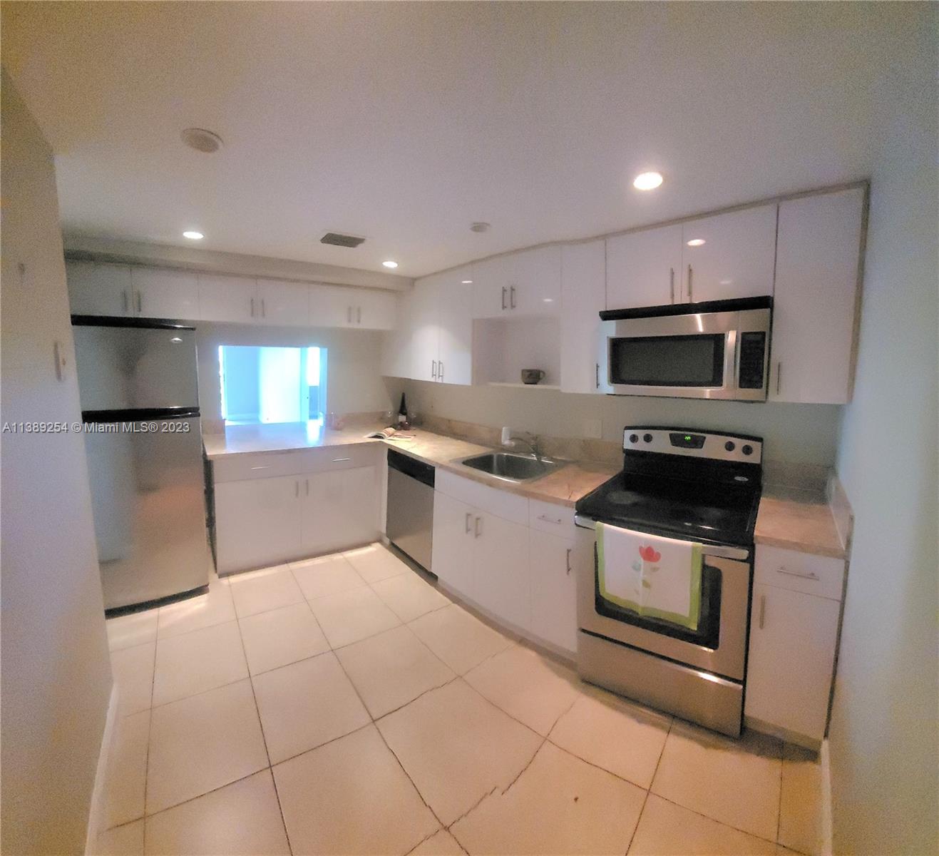 3490 Foxcroft Road, Unit B202 Miramar, FL 33025 - Photo 15 of 29 a kitchen with stainless steel appliances granite countertop a stove a sink and a microwave
