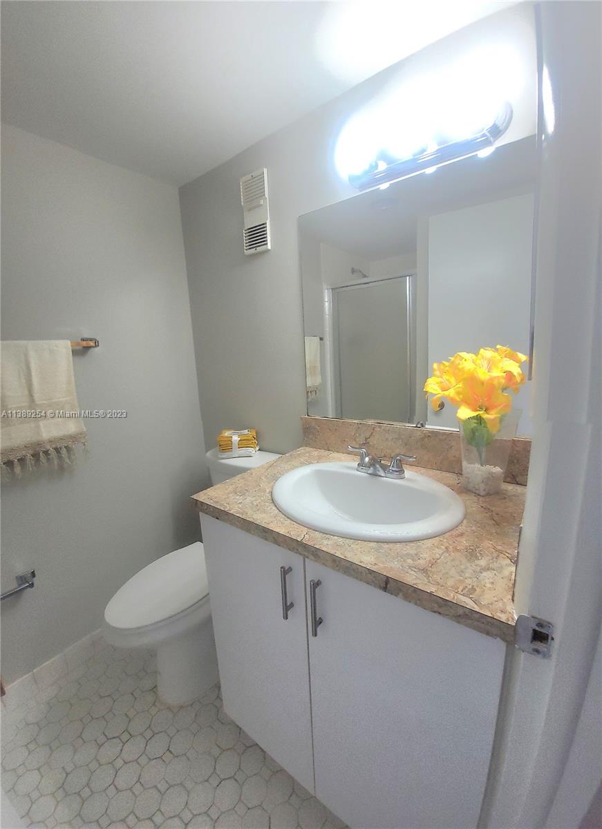 3490 Foxcroft Road, Unit B202 Miramar, FL 33025 - Photo 28 of 29 a bathroom with a granite countertop sink a toilet and a mirror