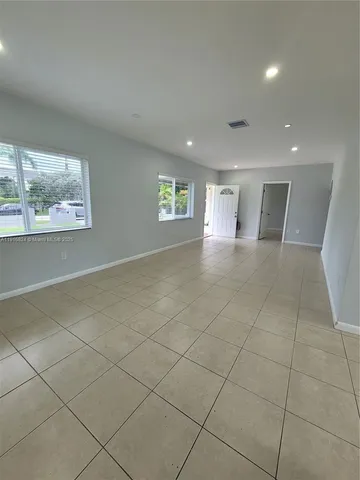 a view of an empty room with a sink and a window