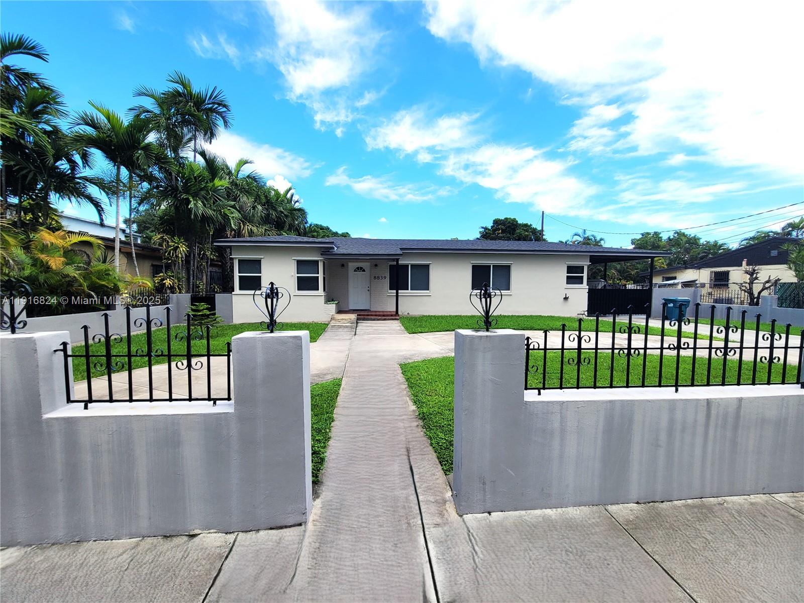 8839 Southwest 28th Street Miami, FL 33165 - Photo 2 of 29 a front view of a house with a garden