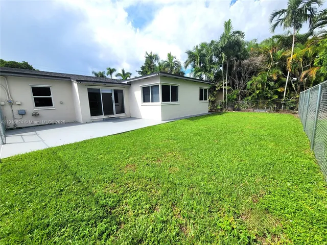 a view of a patio with a table chairs potted plants and a palm tree