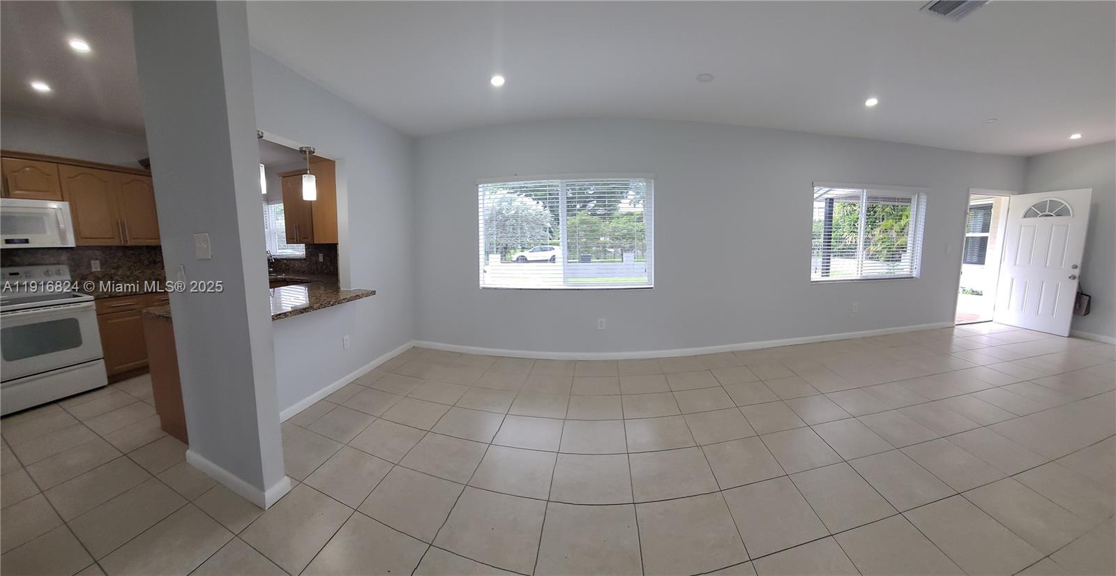 8839 Southwest 28th Street Miami, FL 33165 - Photo 6 of 29 an empty room with kitchen view and windows