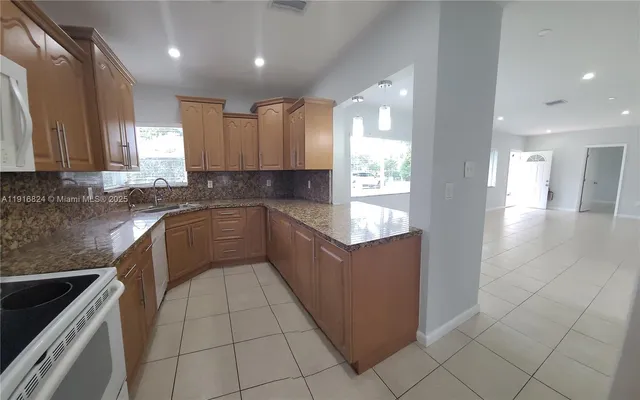 a kitchen with a sink a counter top space stainless steel appliances and cabinets