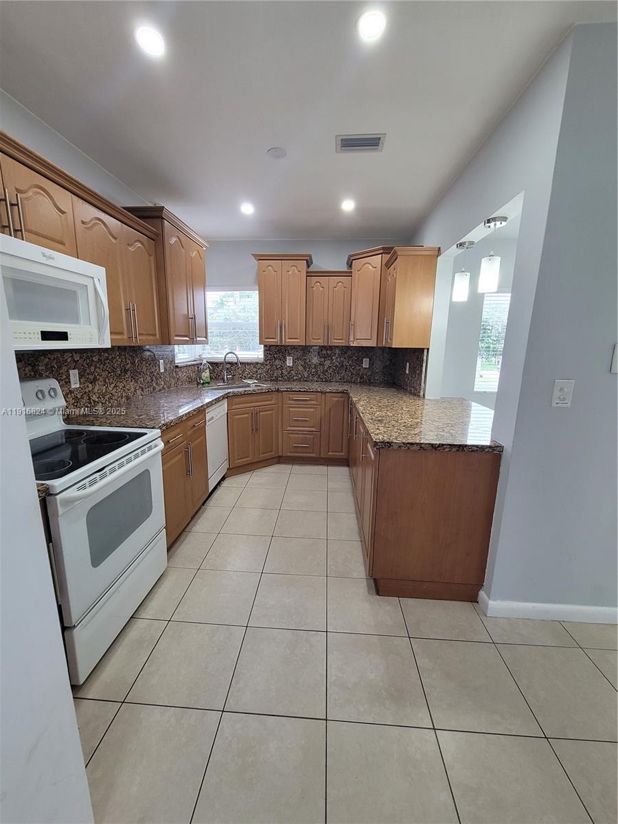 8839 Southwest 28th Street Miami, FL 33165 - Photo 8 of 29 a kitchen with stainless steel appliances granite countertop a stove a sink and a refrigerator