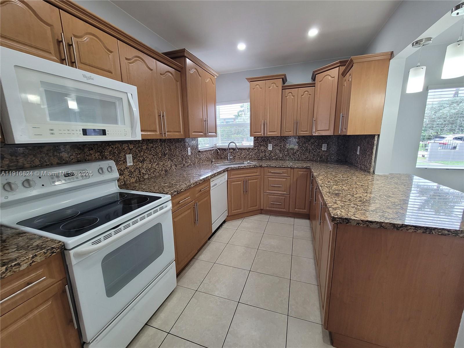 8839 Southwest 28th Street Miami, FL 33165 - Photo 9 of 29 a kitchen with a stove sink and cabinets