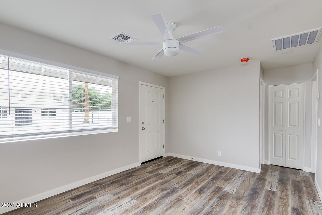 1648 West Colter Street, Unit 2 Phoenix, AZ 85015 - Photo 3 of 17 a view of an empty room with wooden floor and a window
