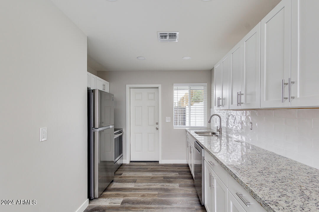 1648 West Colter Street, Unit 2 Phoenix, AZ 85015 - Photo 5 of 17 a kitchen with granite countertop a sink and refrigerator
