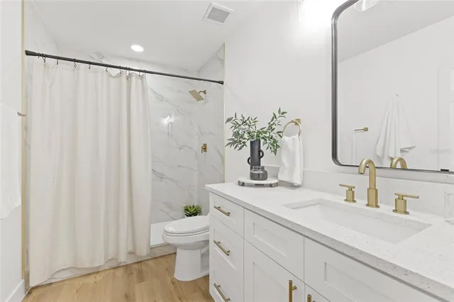 a bathroom with a sink a toilet and shower curtain