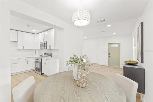 a kitchen with a refrigerator and white cabinets