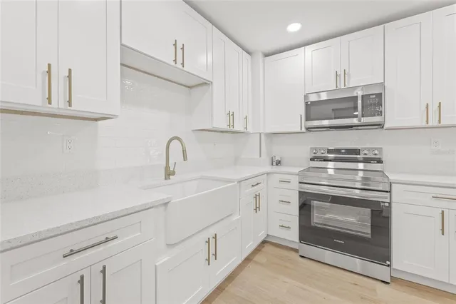 a kitchen with stainless steel appliances granite countertop white cabinets a sink and dishwasher