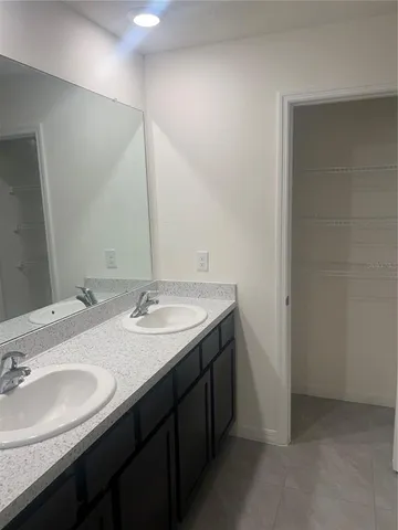 a bathroom with double sink and a mirror