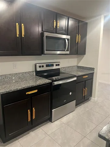 a kitchen with stainless steel appliances granite countertop a stove and a microwave