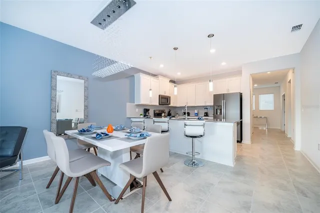 a kitchen with stainless steel appliances kitchen island granite countertop a dining table chairs and view of living room