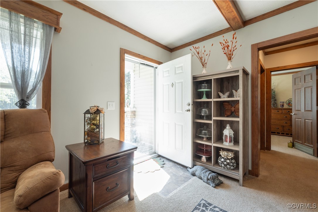 566 Cheaneys Bridge Road Dunnsville, VA 22454 - Photo 8 of 50 Foyer entrance with light carpet, beam ceiling, an