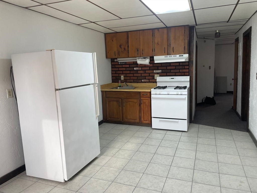 230 Pearl Street, Unit 1 Somerville, MA 02145 - Photo 3 of 11 a kitchen with a refrigerator a stove a washer and dryer
