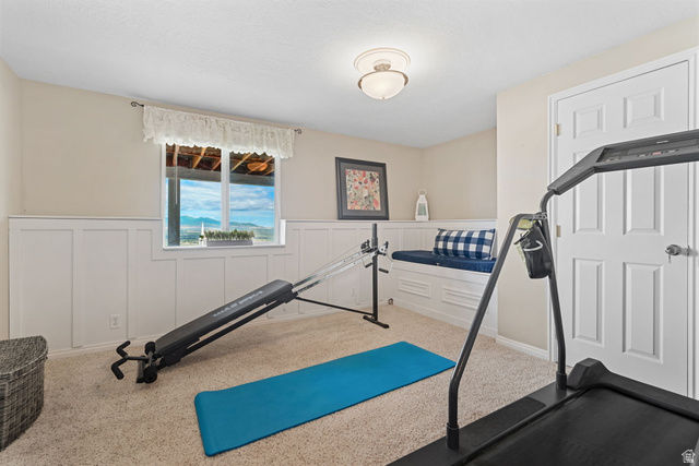 14883 Tooele Lane Draper, UT 84020 - Photo 38 of 49 Carpeted room featuring a window with exterior scenery, white wainscoting, a built-in window bench, a flush mount ceiling light, and a white paneled door