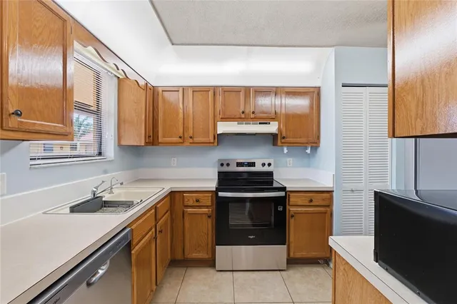 a kitchen with stainless steel appliances granite countertop a sink stove and cabinets