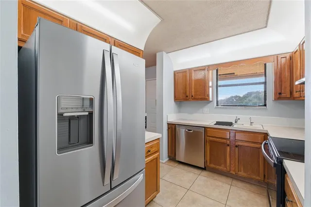 a kitchen with stainless steel appliances granite countertop a refrigerator and a sink