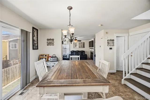 a dining room with furniture a chandelier and wooden floor