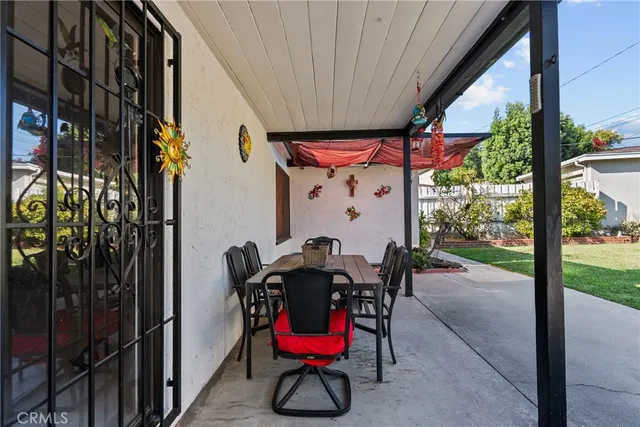 a view of a porch with a table and chairs