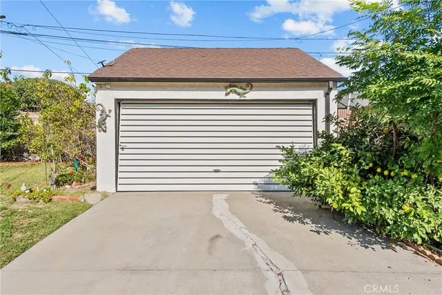 a view of a house with a yard and potted plants