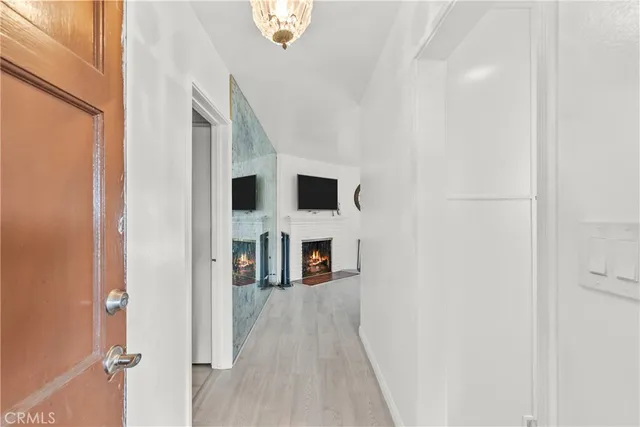 a view of a hallway with wooden floor and dining room