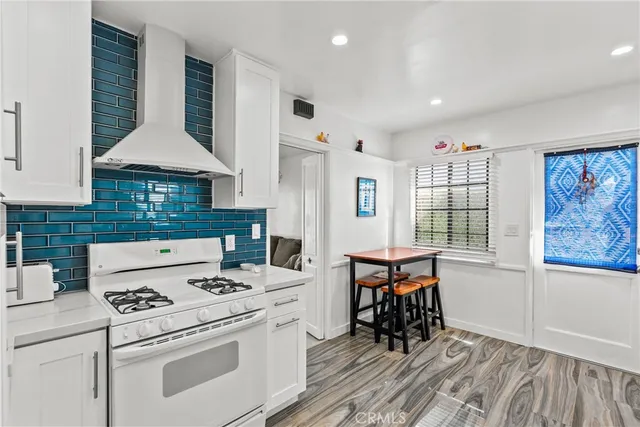 a kitchen that has a stove a table and chairs in it