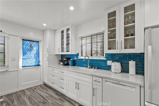a kitchen with stainless steel appliances granite countertop a sink a stove and cabinets