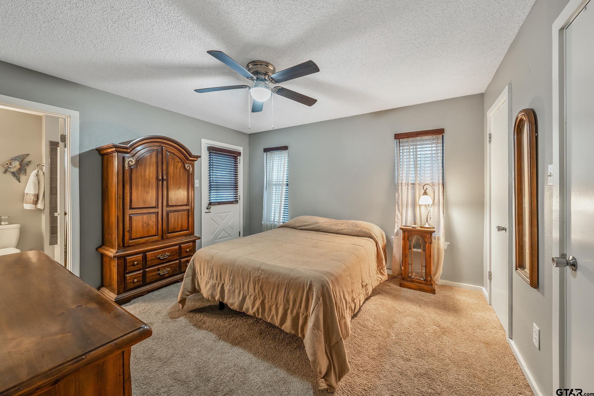 201 Elmwood Lane Holly Lake Ranch, TX 75765 - Photo 13 of 34 a bedroom with a bed and a refrigerator