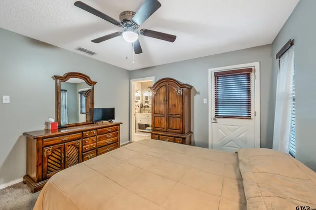 a bedroom with a bed dresser and a large window