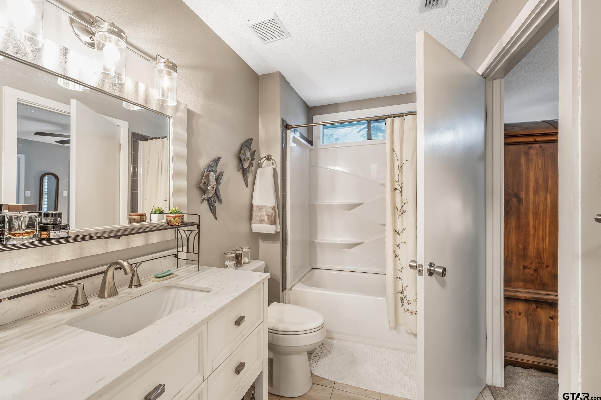 201 Elmwood Lane Holly Lake Ranch, TX 75765 - Photo 15 of 34 a bathroom with a double vanity sink toilet mirror and shower