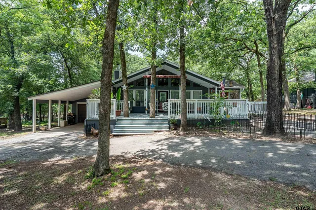 a view of a house with a yard and large tree