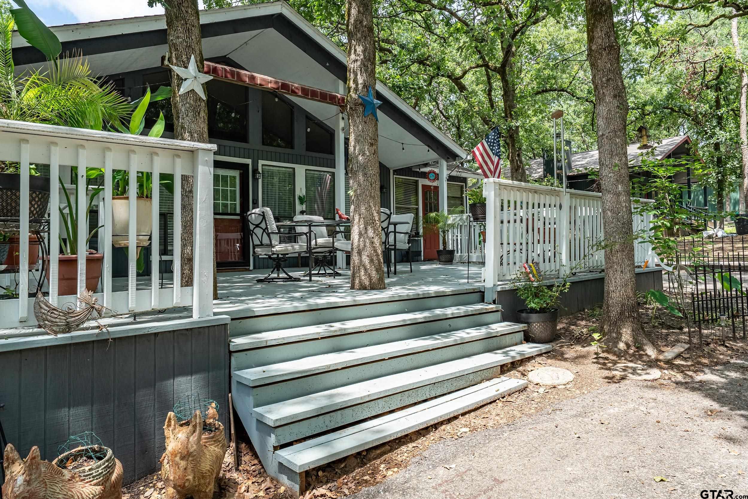 201 Elmwood Lane Holly Lake Ranch, TX 75765 - Photo 2 of 34 a view of a chair and tables in patio of the house