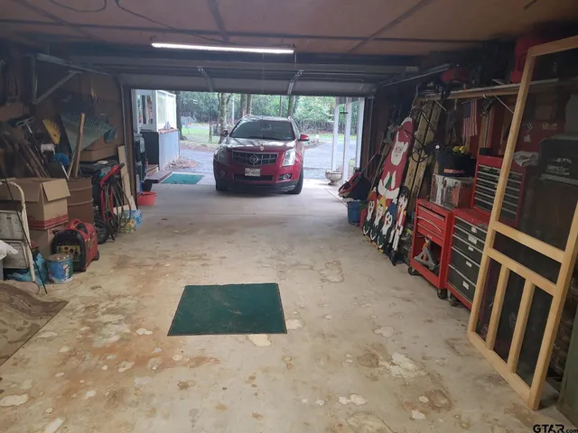 a view of an empty room with wooden floor and a rug